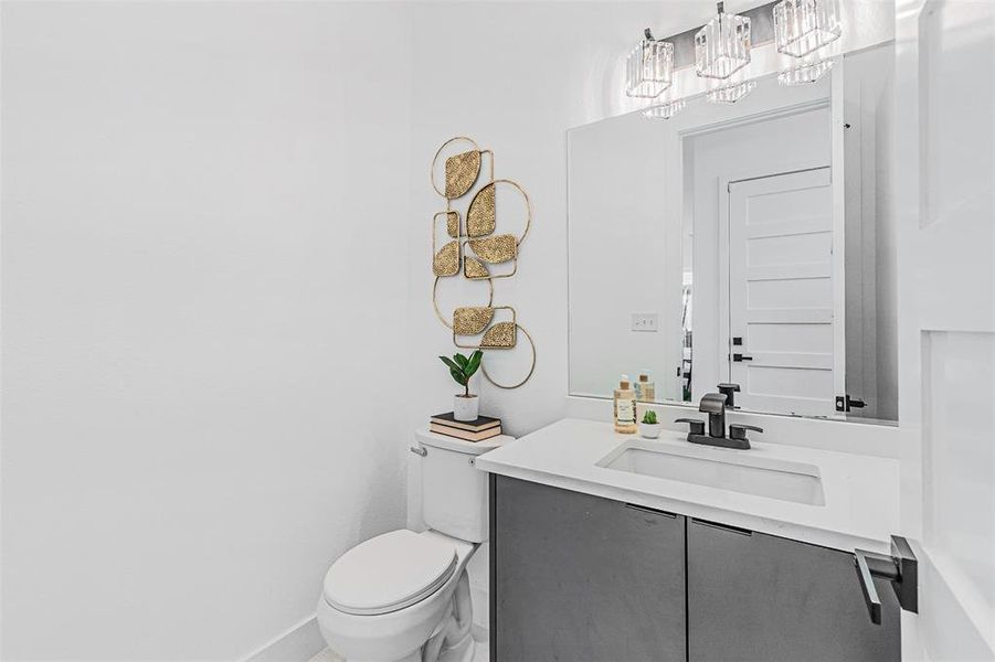 Half bath featuring vanity and a chandelier Half bath featuring vanity and a chandelier