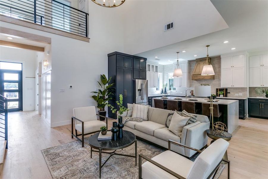 Living room with a high ceiling, sink, and light hardwood / wood-style flooring