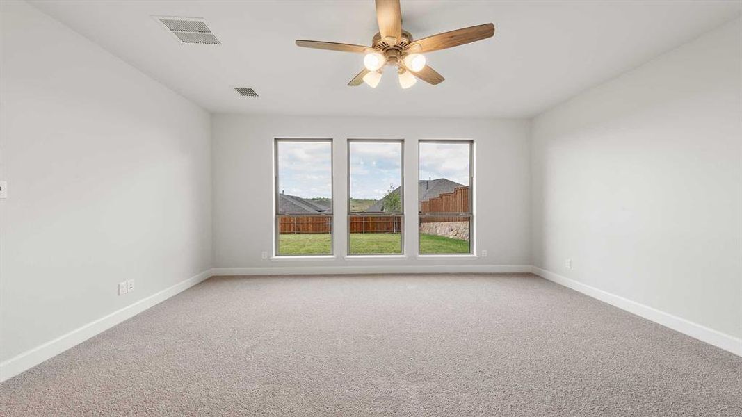 Carpeted empty room with ceiling fan