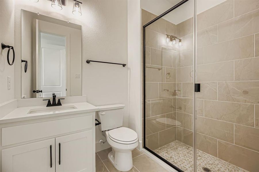 Bathroom with vanity, a shower stall, and light tile patterned floors Bathroom with vanity, a shower stall, and light tile patterned floors