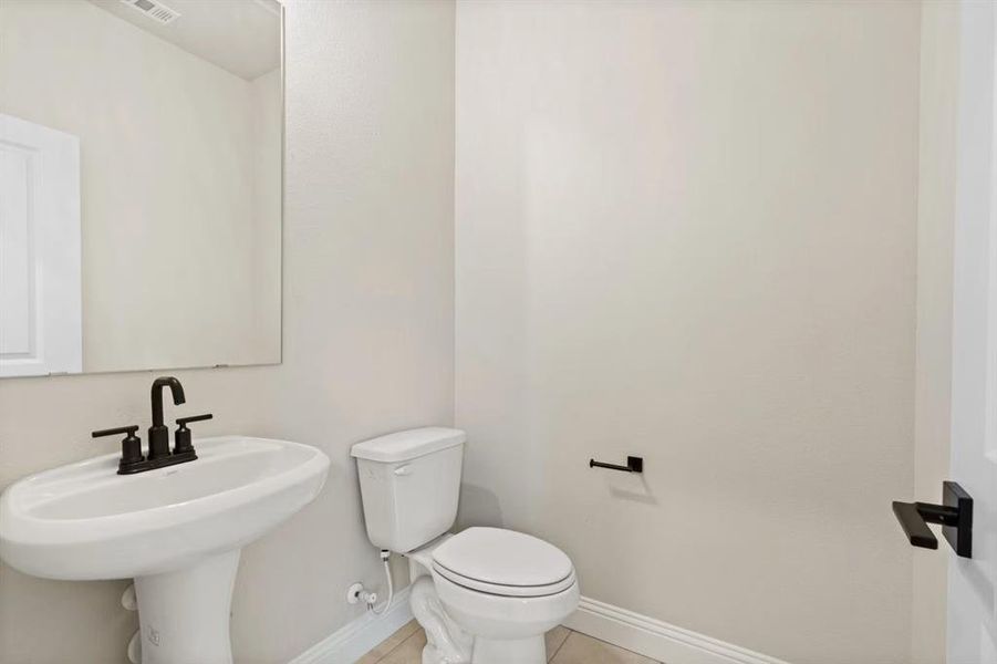 Bathroom featuring sink, tile patterned floors, and toilet