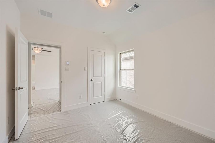 Unfurnished bedroom with light carpet, a closet, and vaulted ceiling