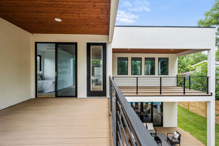 A modern outdoor living space, featuring wood-planked decks and sleek black railings, offers elevated views. A modern outdoor living space, featuring wood-planked decks and sleek black railings, offers elevated views.