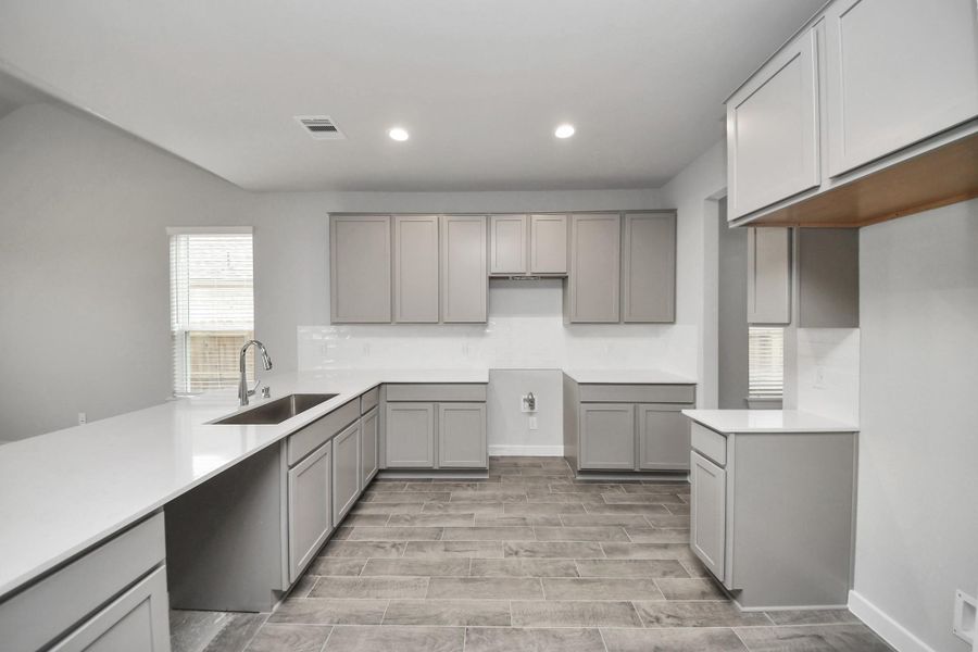 The kitchen is a culinary haven, featuring granite countertops, a tile backsplash, stainlesssteel appliances, and 42” upper cabinets.