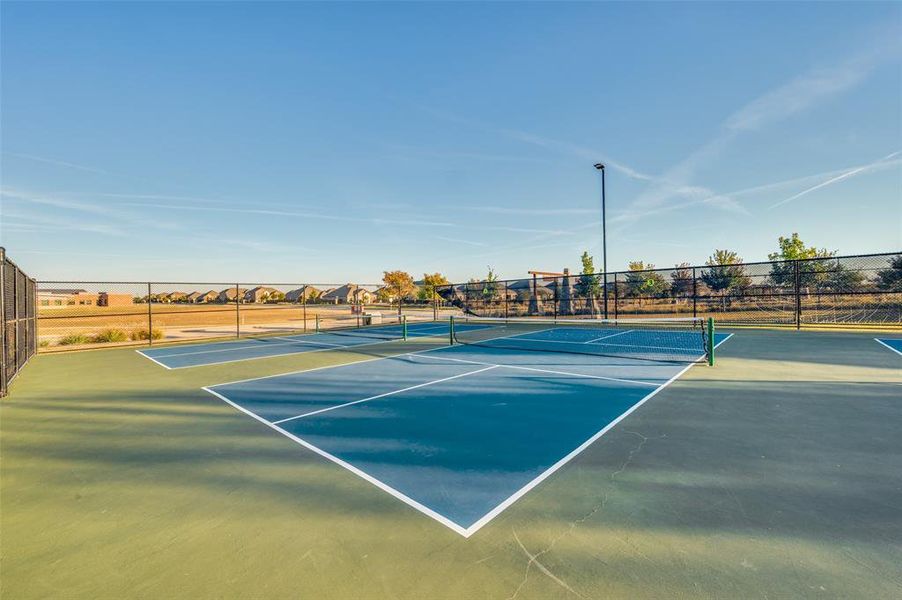 View of tennis court with a residential view