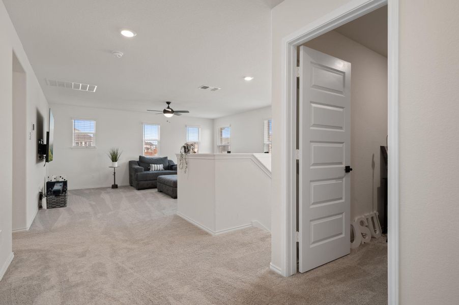 Hallway featuring light carpet and recessed lighting