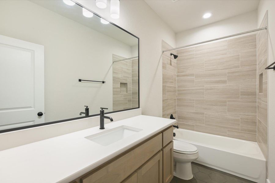 A well-appointed bathroom with a spacious vanity, sleek fixtures, and a tub-shower combination.
