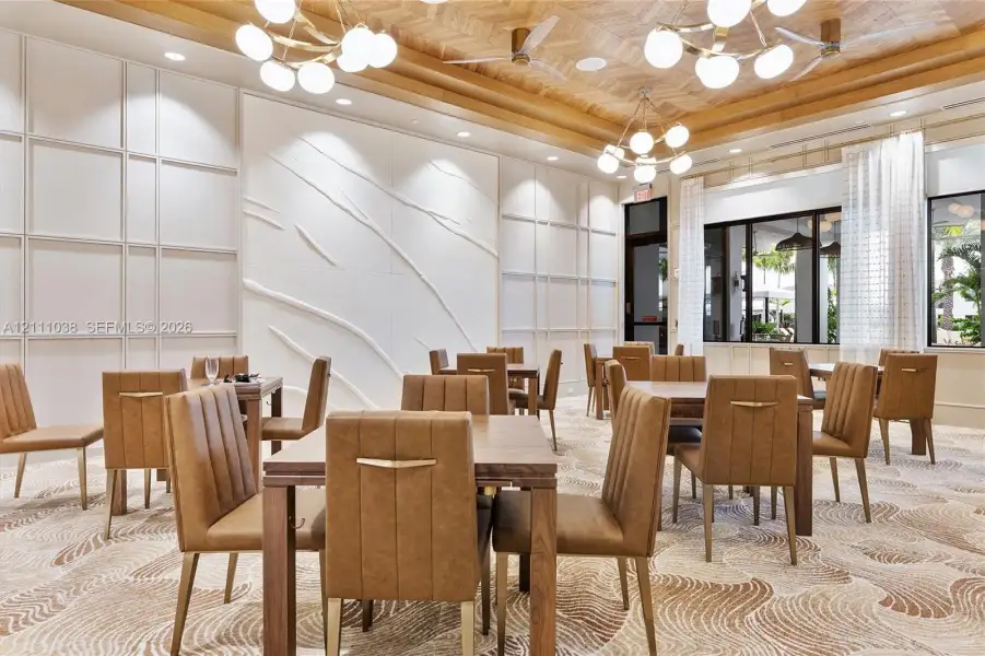 Herringbone wood-paneled ceiling featuring multi-globe chandeliers and intricate wall paneling with a raised sculptural feature