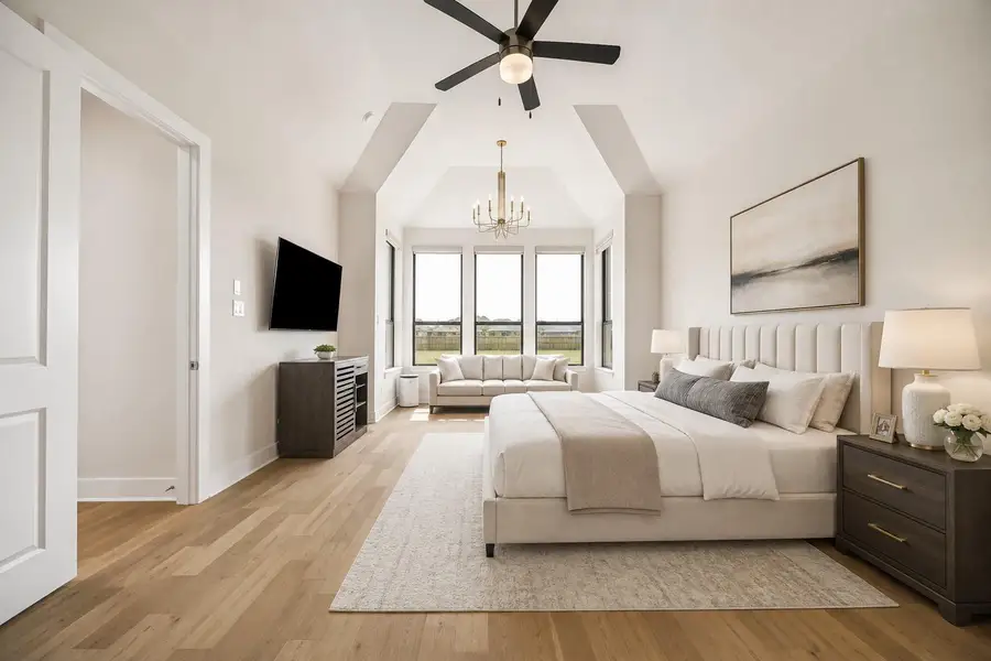 PRIMARY BEDROOM FEATURES A SPACIOUS LAYOUT, VAULTED CEILING, WOOD FLOORING, AND A WALL OF WINDOWS THAT FILLS THE ROOM WITH NATURAL LIGHT. **Virtually Staged. PRIMARY BEDROOM FEATURES A SPACIOUS LAYOUT, VAULTED CEILING, WOOD FLOORING, AND A WALL OF WINDOWS THAT FILLS THE ROOM WITH NATURAL LIGHT. **Virtually Staged.