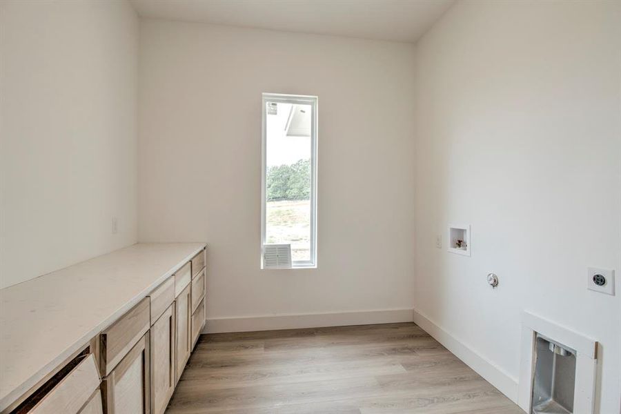 Laundry area with light wood finished floors, hookup for a washing machine, and hookup for a gas dryer Laundry area with light wood finished floors, hookup for a washing machine, and hookup for a gas dryer