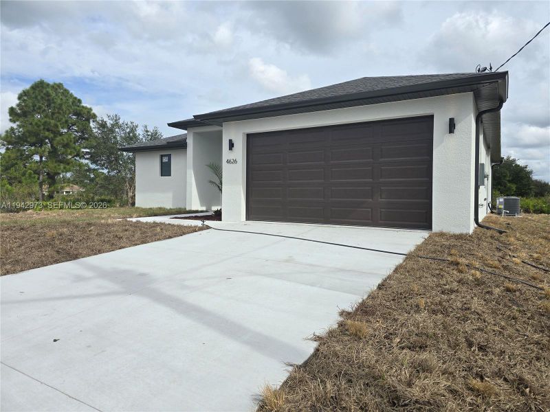 Front exterior of a new home in , Lehigh Acres, FL, highlighting curb appeal (Image 16).