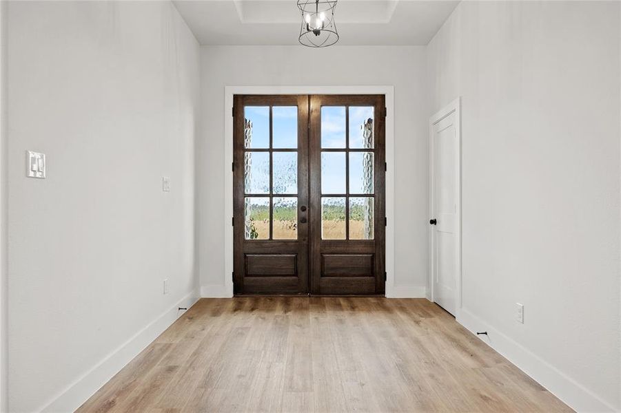 Doorway featuring wood finished floors, french doors, and hanging lights