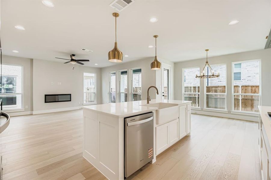 Kitchen featuring dishwasher, light wood-style flooring, healthy amount of natural light, white cabinetry, and recessed lighting