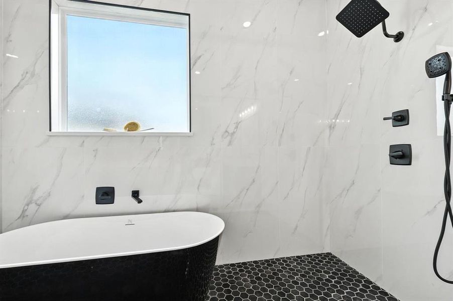 Full bathroom featuring a soaking tub and a marble finish shower Full bathroom featuring a soaking tub and a marble finish shower