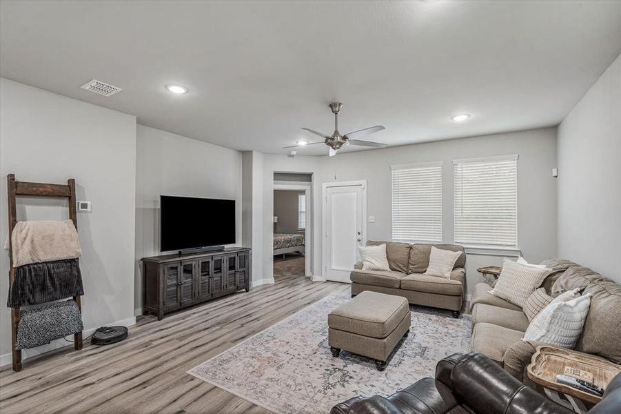 Living room with ceiling fan and light hardwood / wood-style flooring