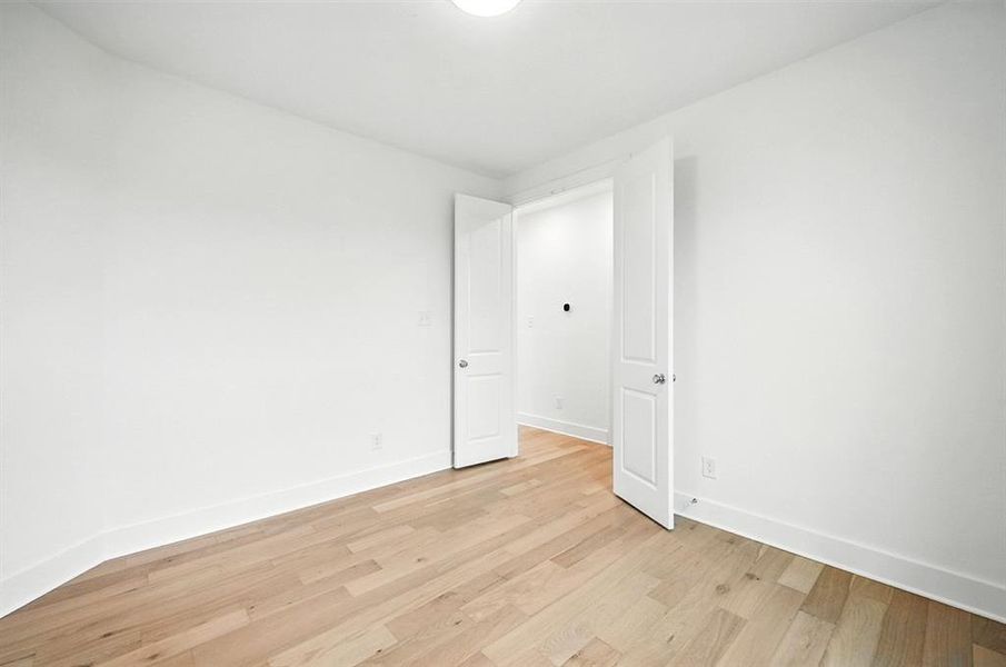 Spare room with light wood-style floors and baseboards Spare room with light wood-style floors and baseboards
