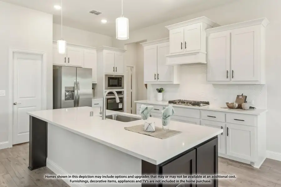 Kitchen with white cabinets, large island, quartz countertops, and stainless steel appliances