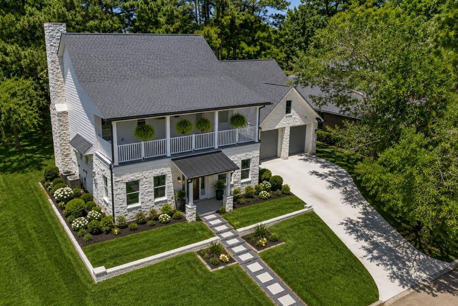 Drone footage of the beautiful exterior, stone fascia, upstairs balcony, situated atop an elevated lot to maximize views and outdoor enjoyment. Drone footage of the beautiful exterior, stone fascia, upstairs balcony, situated atop an elevated lot to maximize views and outdoor enjoyment.