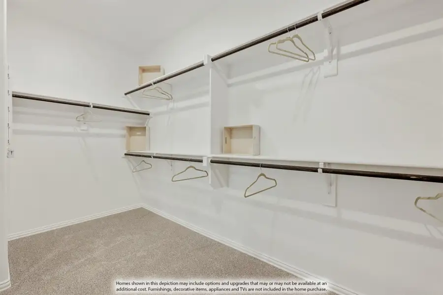 Walk-in closet with double hanging rods, white shelving, and beige carpet flooring Walk-in closet with double hanging rods, white shelving, and beige carpet flooring