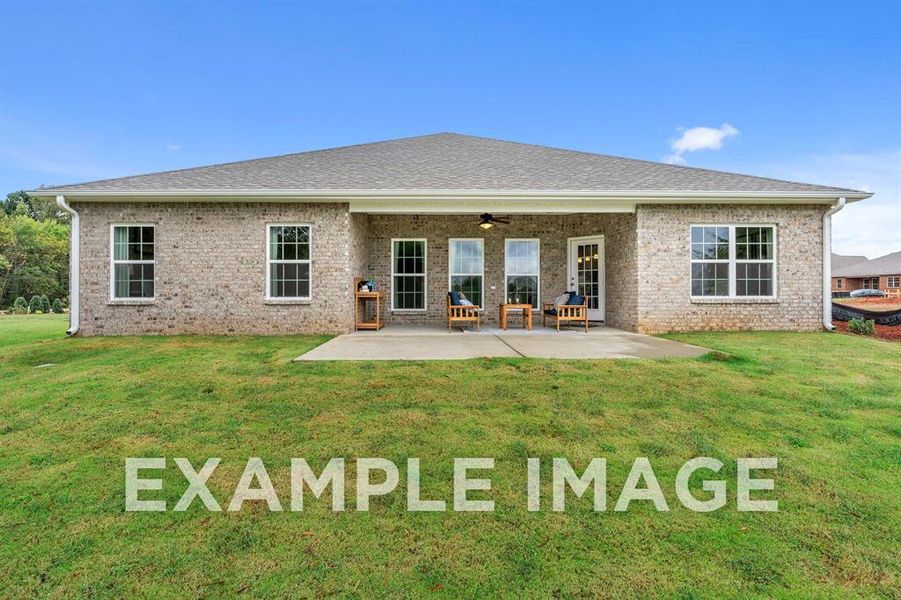 Rear view of house featuring ceiling fan, a patio area, and a lawn