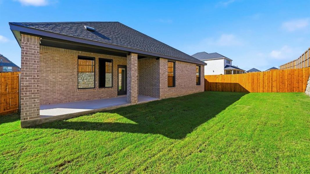 Rear view of property with a fenced backyard, a patio area, brick siding, and roof with shingles Rear view of property with a fenced backyard, a patio area, brick siding, and roof with shingles