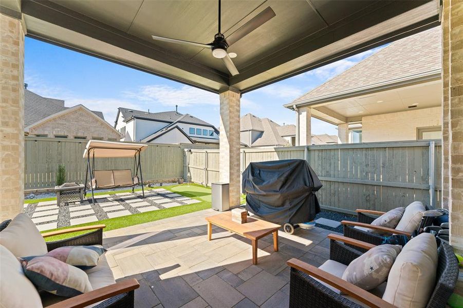 The covered patio features a ceiling fan, providing a comfortable outdoor living space