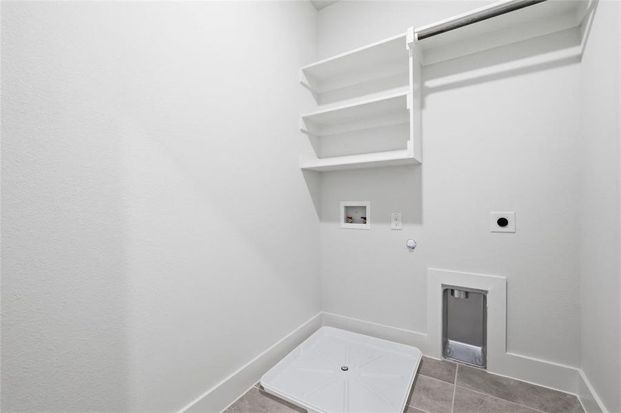 The utility area features white walls, built-in shelving, a clothes rod, and tile flooring