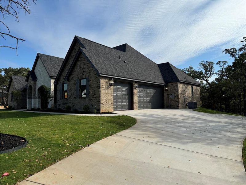 View of front of property with brick siding, a front lawn, an attached garage, concrete driveway, and roof with shingles View of front of property with brick siding, a front lawn, an attached garage, concrete driveway, and roof with shingles