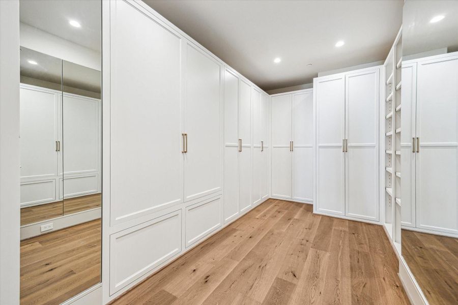 Full wardrobe boxes with custom-fabricated doors and soft-close hinges keep all of your clothes fresh and organized for you. Valet rods for dry cleaning, accessory shelves, and built-in hamper complete this streamlined look.