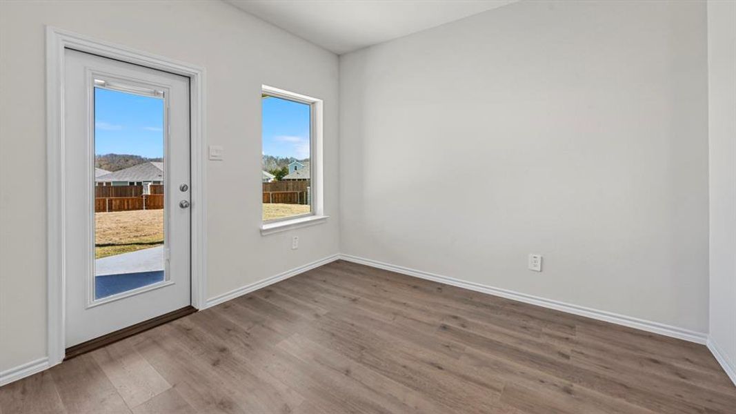 Unfurnished room with wood finished floors and baseboards