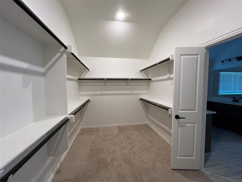 Large walk-in master closet with carpet flooring and recessed lighting. Large walk-in master closet with carpet flooring and recessed lighting.