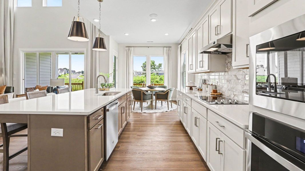 Kitchen with quartz countertops, tile backsplash, and pendant lighting