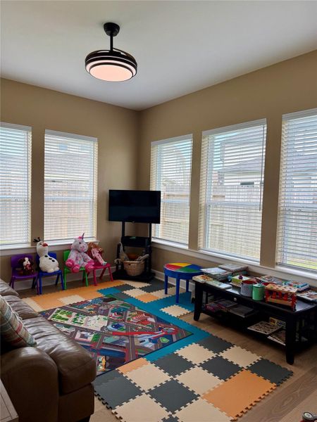 Retreat area utilized as  a Bright and inviting playroom featuring large windows, colorful foam flooring, and ample space for toys and activities.