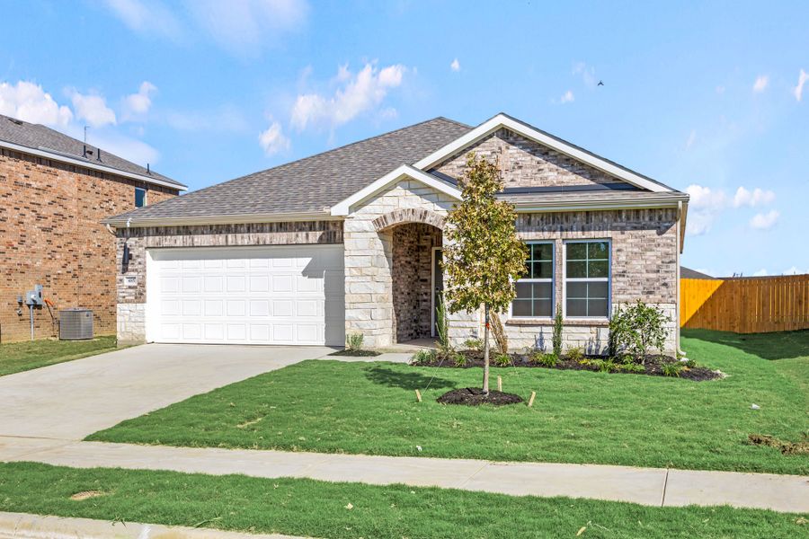 A house with a garage and a tree in the front.