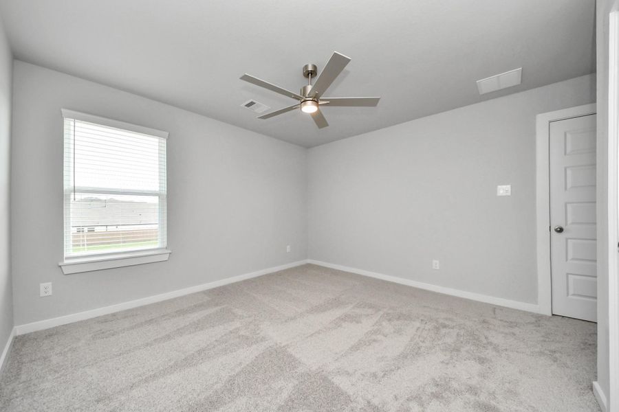 Secondary bedroom features plush carpeting, large windows that let in plenty of natural light, bright paint, and spacious closets.