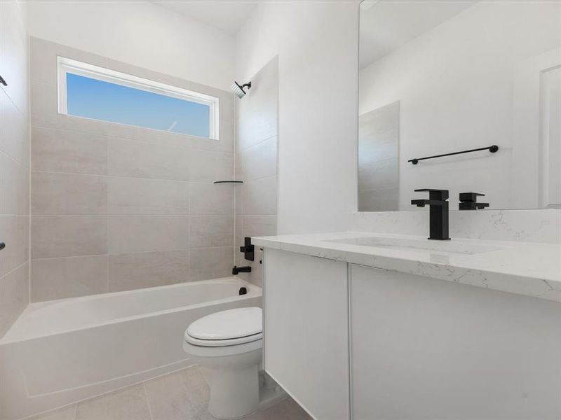 Ensuite Bathroom with tub / shower combination, vanity, and light tile patterned floors