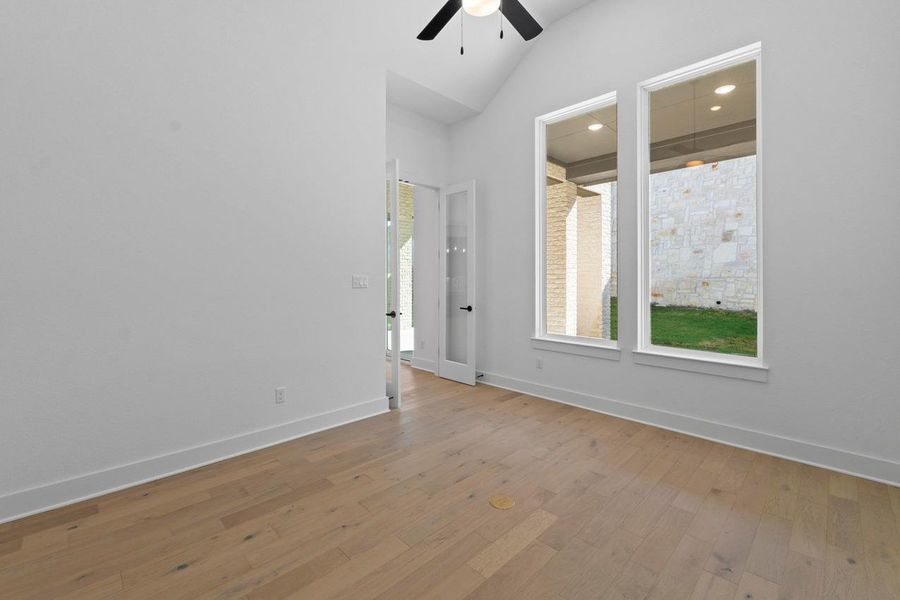 Spare room featuring light wood-style flooring, lofted ceiling, and ceiling fan Spare room featuring light wood-style flooring, lofted ceiling, and ceiling fan
