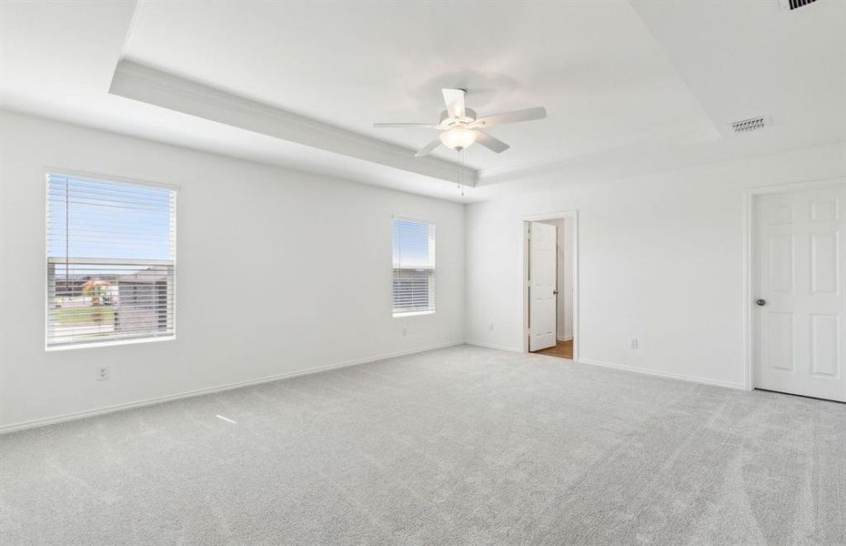 Elegant owner's suite with tray ceiling *real home pictured