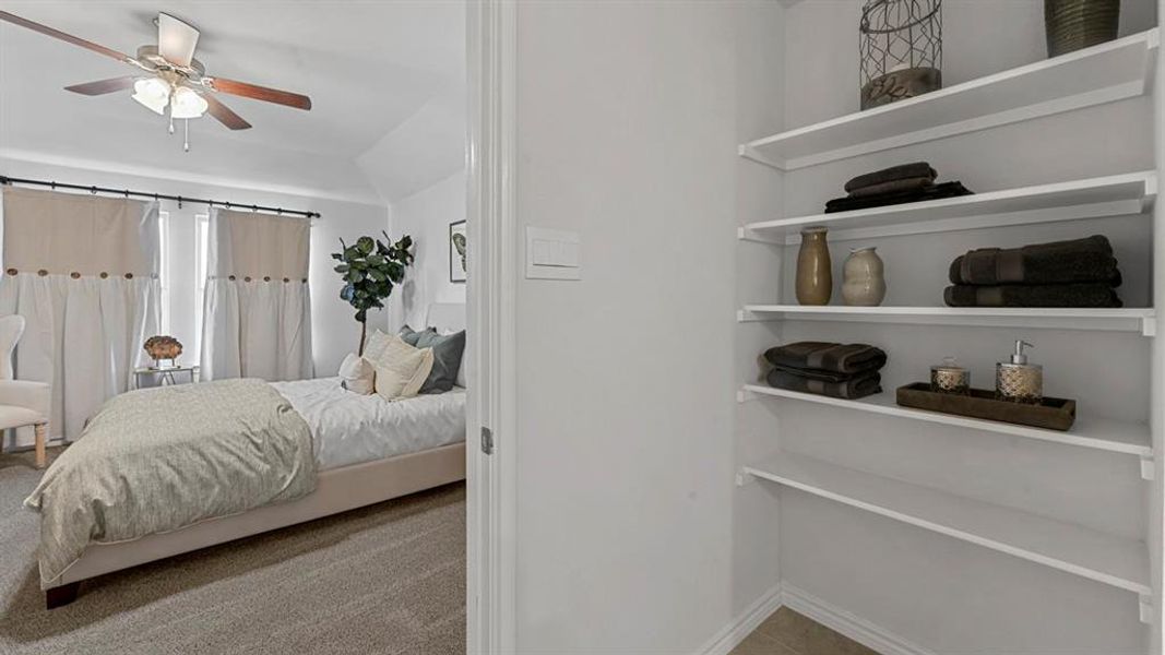 Bedroom featuring lofted ceiling, a ceiling fan, and light carpet