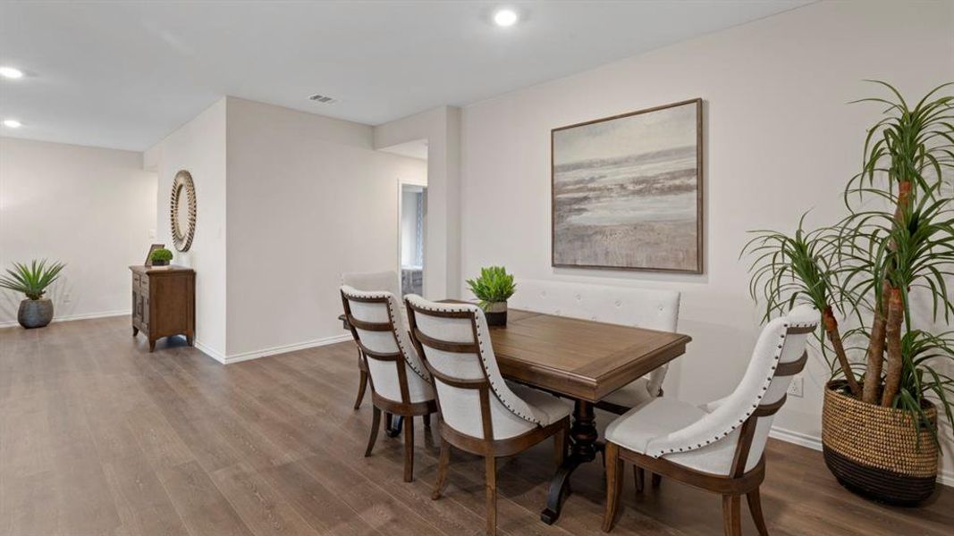 Dining room with dark wood-type flooring and recessed lighting