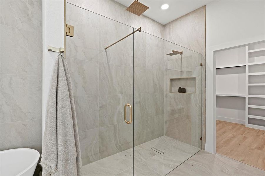 Bathroom featuring a stall shower, a freestanding bath, and a walk in closet Bathroom featuring a stall shower, a freestanding bath, and a walk in closet