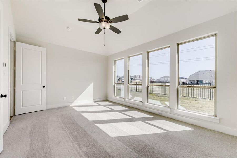 Unfurnished room featuring light carpet, ceiling fan, lofted ceiling, and a residential view