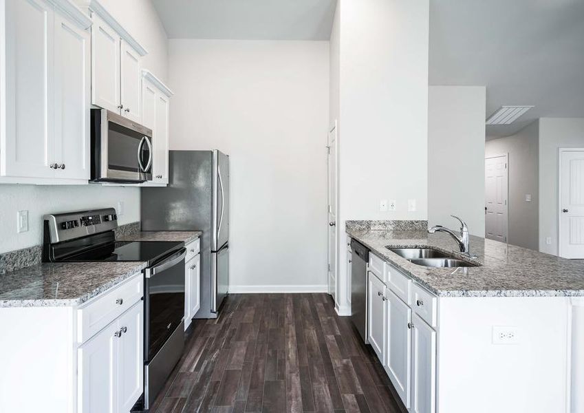 Chef-ready kitchen with granite countertops, white cabinetry and stainless steel appliances.
