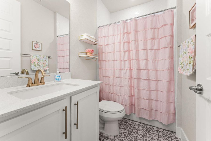 The second bathroom is on the first floor, right next to Bedroom 2.  It is a full bath with a decorative tile floor.