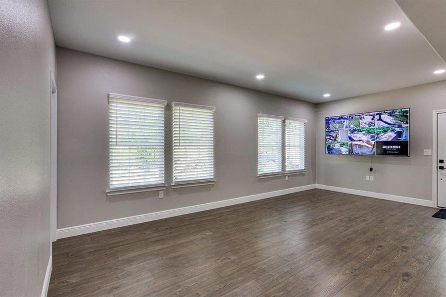 Unfurnished living room with dark wood-type flooring and recessed lighting