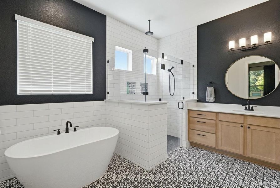 Indulge in a tranquil retreat featuring a freestanding soaking tub, a spacious glass-enclosed shower, and a custom vanity. Indulge in a tranquil retreat featuring a freestanding soaking tub, a spacious glass-enclosed shower, and a custom vanity.