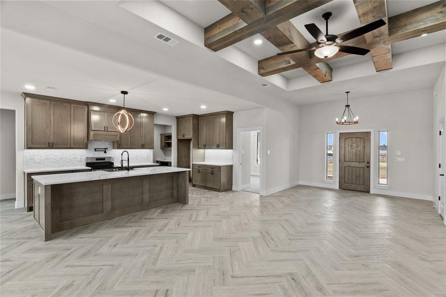 Kitchen with pendant lighting, beam ceiling, and backsplash