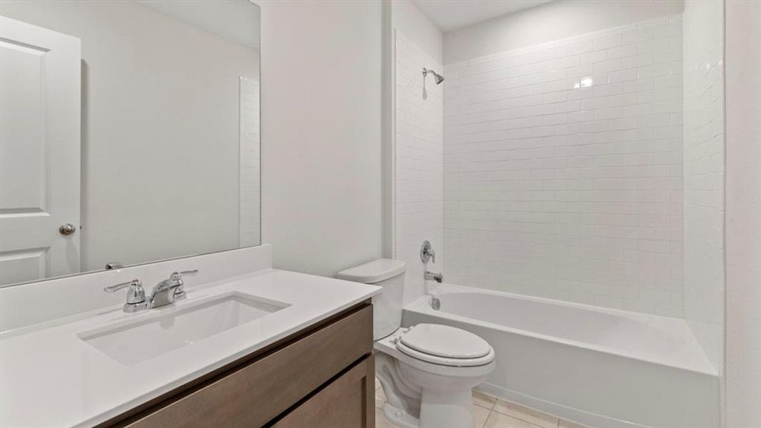 Bathroom featuring a vanity with an integrated sink, polished chrome faucet, and a large wall-mounted mirror