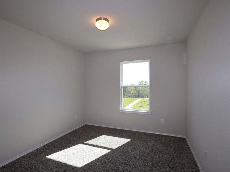 Empty room featuring baseboards and dark colored carpet