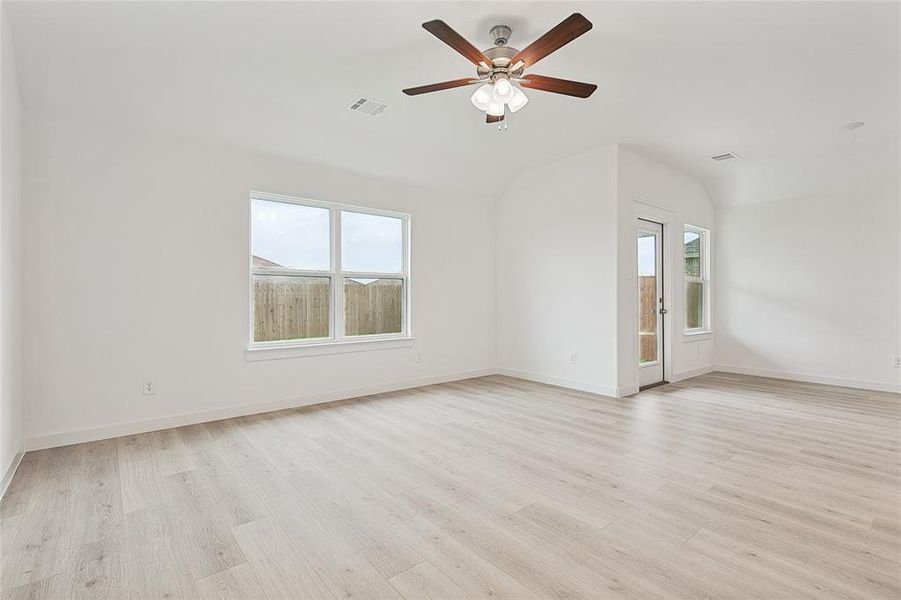 Unfurnished room featuring lofted ceiling, light wood-type flooring, and ceiling fan